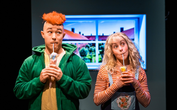 Poika ja tyttö seisovat vierekkäin. Molemmat juovat mehua pillillä ja katasovat pois päin toisistaan.