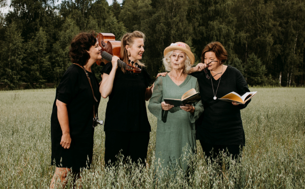 Neljä naista seisoo pellolla. 